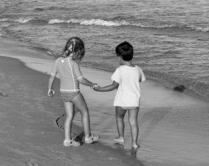 children-holding-hands-black-white-beach